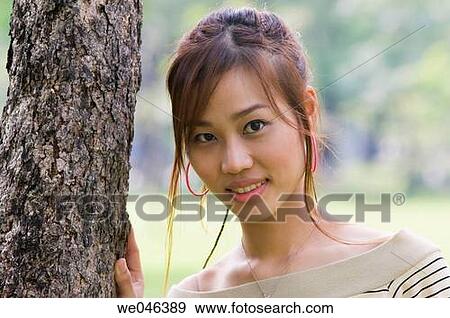 Stock Photo - Thailand, Bangkok, Lumpini Park, portrait of Thai girl? Jane? next to tree, MR_0604-0004_Jan. Fotosearch