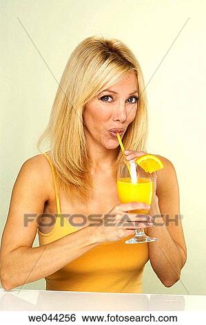 Woman drinking orange with straw View Large Photo Image Stock Photograph - Woman drinking orange with straw. Fotosearch