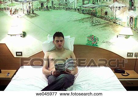 Young man on bed View Large Photo Image Stock Photo - Young man on bed. Fotosearch