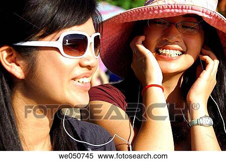 2 asian girls listening to music together, View Large Photo Image Stock Photography - 2 asian girls listening to music together,. Fotosearch