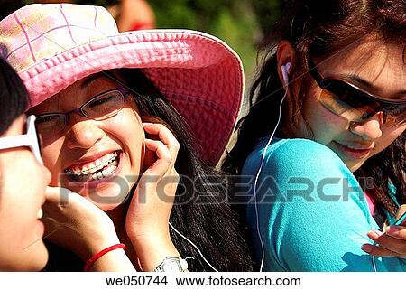 3 asian girls laughing, listening to music together View Large Photo Image Picture - 3 asian girls laughing, listening to music together. Fotosearch