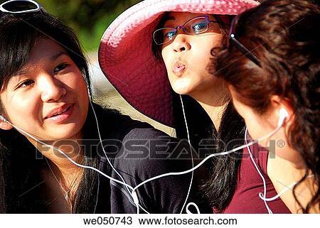 3 asian girls listening to music with earphones together View Large Photo Image Stock Image - 3 asian girls listening to music with earphones together. Fotosearch