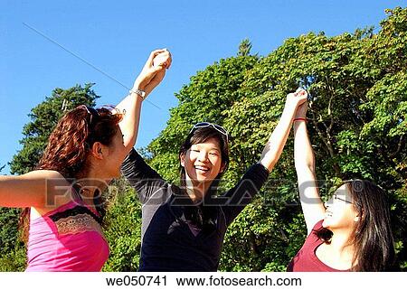 3 asian girls raising hands together View Large Photo Image Stock Image - 3 asian girls raising hands together. Fotosearch