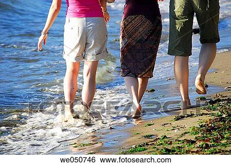 Stock Photograph - 3 asian girls walking along the beach together. Fotosearch