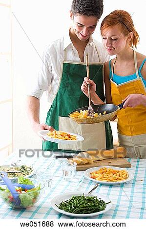 Stock Photo - amusement, Best friend, at-home, apron, 20's. Fotosearch