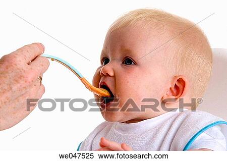 Baby fed with a spoon View Large Photo Image Stock Photography - Baby fed with a spoon. Fotosearch