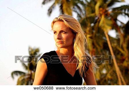 Beautiful blonde woman with palm trees in the background. View Large Photo Image Stock Photo - Beautiful blonde woman with palm trees in the background.. Fotosearch