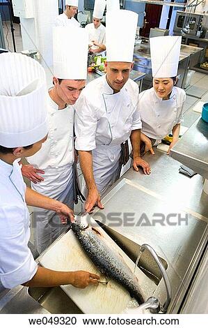 Stock Image - Chefs boning salmon. Luis Irizar cooking school. Donostia, Gipuzkoa, Basque Country, Spain. Fotosearch