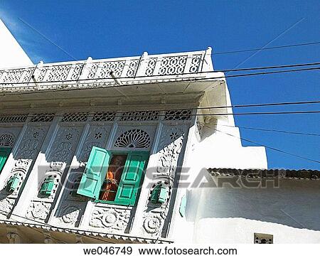 Stock Photo - Indian woman in sari looking through window from old haveli. Udaipur. Rajasthan. India. Fotosearch