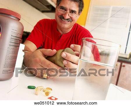 Stock Image - Man taking pills.. Fotosearch