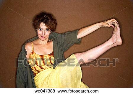 Middle-age woman holding the toes of her outstretched foot View Large Photo Image Stock Photo - Middle-age woman holding the toes of her outstretched foot. Fotosearch