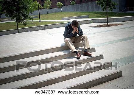 Middle-aged man sitting on concrete steps outside in a courtyard View Large Photo Image Stock Photo - Middle-aged man sitting on concrete steps outside in a courtyard. Fotosearch