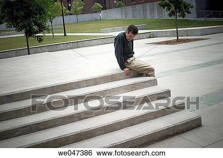 Middle-aged man sitting on concrete steps outside in a courtyard View Large Photo Image Stock Photograph - Middle-aged man sitting on concrete steps outside in a courtyard. Fotosearch