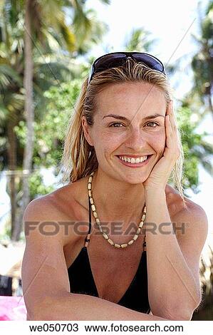 Portrait of a good_looking blonde caucasian woman wearing bikini sat on a beach in India, smiling at camera. View Large Photo Image Stock Image - Portrait of a good_looking blonde caucasian woman wearing bikini sat on a beach in India, smiling at camera.. Fotosearch