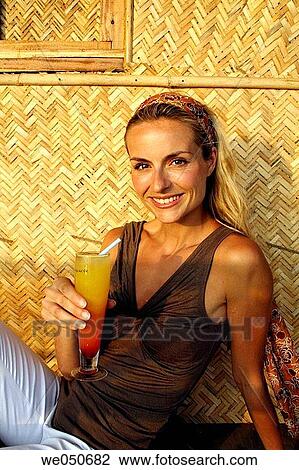 Portrait of beautiful blonde woman drinking a cocktail, shot in an Indian beach hut. View Large Photo Image Stock Image - Portrait of beautiful blonde woman drinking a cocktail, shot in an Indian beach hut.. Fotosearch
