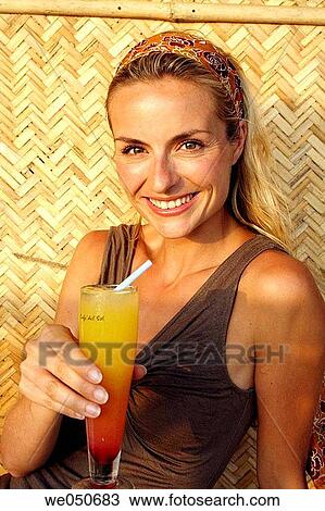 Portrait of beautiful blonde woman drinking a cocktail, shot in an Indian beach hut. View Large Photo Image Stock Image - Portrait of beautiful blonde woman drinking a cocktail, shot in an Indian beach hut.. Fotosearch