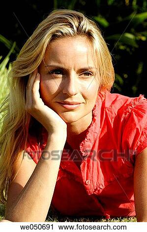 Portrait of blonde woman lying on grass. View Large Photo Image Stock Image - Portrait of blonde woman lying on grass.. Fotosearch