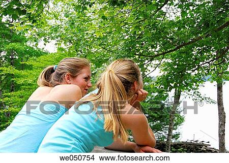 sisters 13 and 18 yrs looking out onto lake View Large Photo Image Picture - sisters 13 and 18 yrs looking out onto lake. Fotosearch