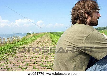 Thoughtful man by road View Large Photo Image Stock Photograph - Thoughtful man by road. Fotosearch