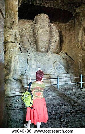 Tourist looking at stone carvings in rock-cut temple on Elephanta Island. Mumbai (ex Bombay). India. View Large Photo Image Stock Photograph - Tourist looking at stone carvings in rock-cut temple on Elephanta Island. Mumbai (ex Bombay). India.. Fotosearch