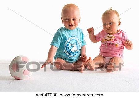 Two toddlers playing with a ball View Large Photo Image Stock Image - Two toddlers playing with a ball. Fotosearch