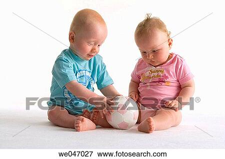 Two toddlers playing with a ball View Large Photo Image Stock Photo - Two toddlers playing with a ball. Fotosearch