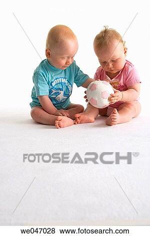 Two toddlers playing with a ball View Large Photo Image Stock Photo - Two toddlers playing with a ball. Fotosearch