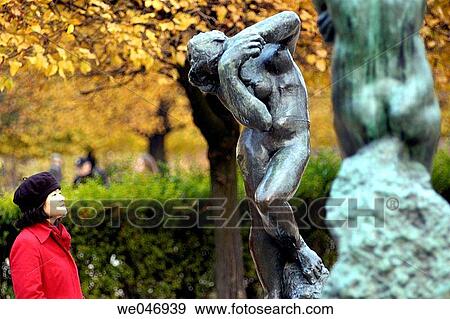 Stock Photo - Woman looking at Rodin statues in Tuileries Gardens and falls colors. Paris. France. Fotosearch