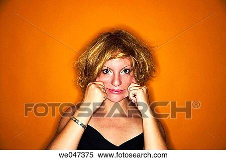 Young blond woman, with messy hair, pulling her cheeks View Large Photo Image Stock Photography - Young blond woman, with messy hair, pulling her cheeks. Fotosearch