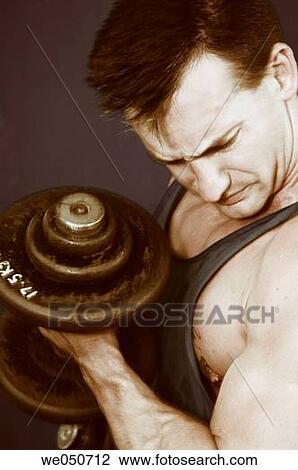 Young Caucasian muscle man in gym, doing biceps curls with dumb bells View Large Photo Image Stock Image - Young Caucasian muscle man in gym, doing biceps curls with dumb bells. Fotosearch
