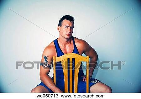 Young Caucasian muscle man with tattoos sitting on chair View Large Photo Image Stock Image - Young Caucasian muscle man with tattoos sitting on chair. Fotosearch
