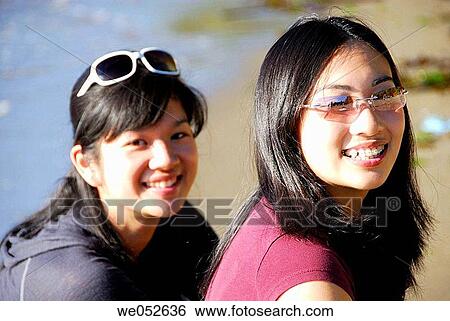 2 asian girls together at the beach smiling, sisters View Large Photo Image Stock Photograph - 2 asian girls together at the beach smiling, sisters. Fotosearch