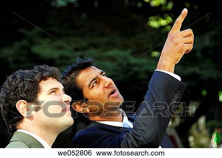 2 young business men pointing and having dicussion View Large Photo Image Stock Photograph - 2 young business men pointing and having dicussion. Fotosearch