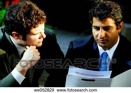 2 young male business men discussing private and confidential file View Large Photo Image Stock Photo - 2 young male business men discussing private and confidential file. Fotosearch