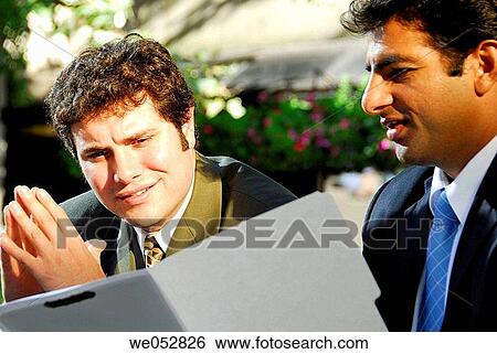 2 young male business men looking at file folder together View Large Photo Image Stock Photograph - 2 young male business men looking at file folder together. Fotosearch