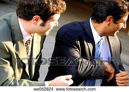 2 young male business men sitting together exchanging business info View Large Photo Image Picture - 2 young male business men sitting together exchanging business info. Fotosearch