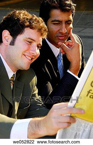 2 young male business men sitting together reading paper View Large Photo Image Stock Image - 2 young male business men sitting together reading paper. Fotosearch