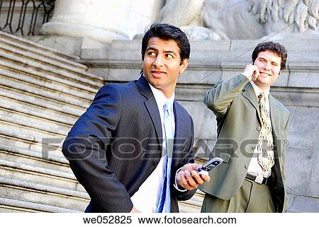 2 young male business men standing on stairs using cell phones View Large Photo Image Stock Photography - 2 young male business men standing on stairs using cell phones. Fotosearch