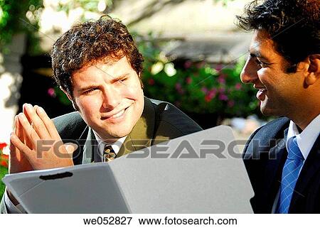 2 young male business ment smiling at each other while holding file folder View Large Photo Image Stock Photo - 2 young male business ment smiling at each other while holding file folder. Fotosearch