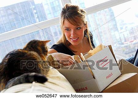 20 yr old woman home shopping on laptop computer looking at pet cat View Large Photo Image Stock Photo - 20 yr old woman home shopping on laptop computer looking at pet cat. Fotosearch