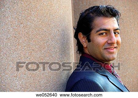 35 yr old ethnic business man smiling while leaning against pillar View Large Photo Image Stock Image - 35 yr old ethnic business man smiling while leaning against pillar. Fotosearch