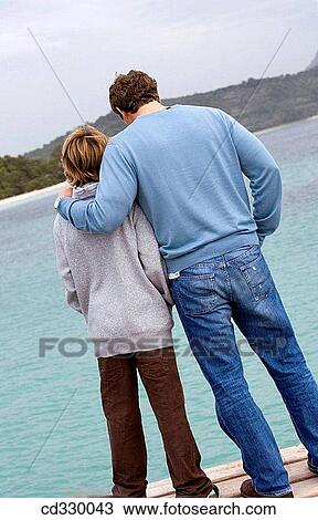 Stock Image - affection, bond, beach, back view, 30's. Fotosearch