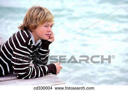 Picture - autumn, boy, blond, beach, absorbed. Fotosearch