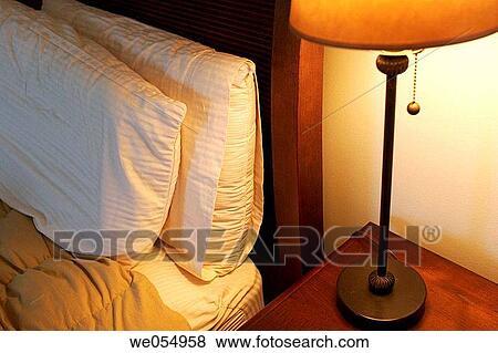 Stock Photo - Bed and night stand with lamp. Fotosearch