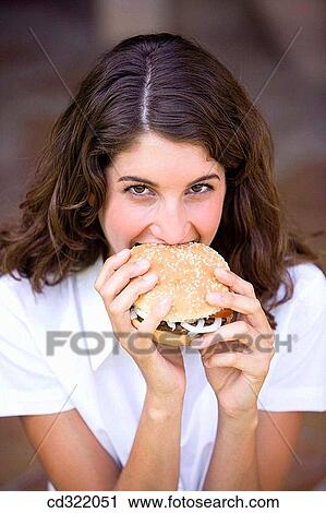 Stock Image - bite, burger, biting, adolescence. Fotosearch