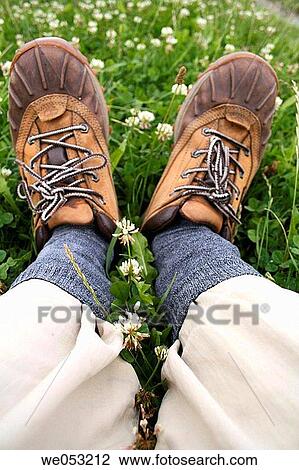 Stock Image - Hiking shoes on meadow with clover. Fotosearch