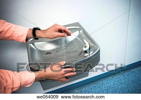 Man washing his hand in a water fountain View Large Photo Image Stock Photo - Man washing his hand in a water fountain. Fotosearch