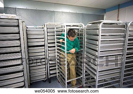 Middle-age man surrounded by racks that are filled with metal trays View Large Photo Image Stock Photography - Middle-age man surrounded by racks that are filled with metal trays. Fotosearch