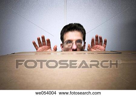 Middle-age man, wearing glasses, peering over a stack of cardboard boxes View Large Photo Image Picture - Middle-age man, wearing glasses, peering over a stack of cardboard boxes. Fotosearch