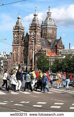 Stock Photography - People crossing Prins Henrikkade near St. Nicolaaskerk, central station, Amsterdam, Holland, Netherlands. Fotosearch